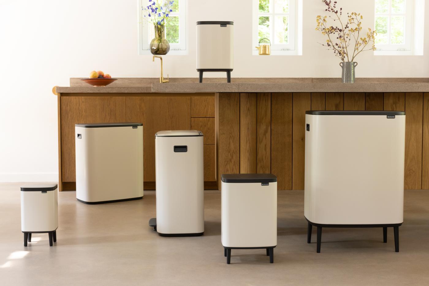 Soft Beige afvalbeheercollectie met Bo Touch Bins in een kamer Alle soorten touch bins van groot tot klein in Soft Beige. Sommige hebben poten en andere niet. De kamer lijkt op een keuken met een warme, gezellige sfeer