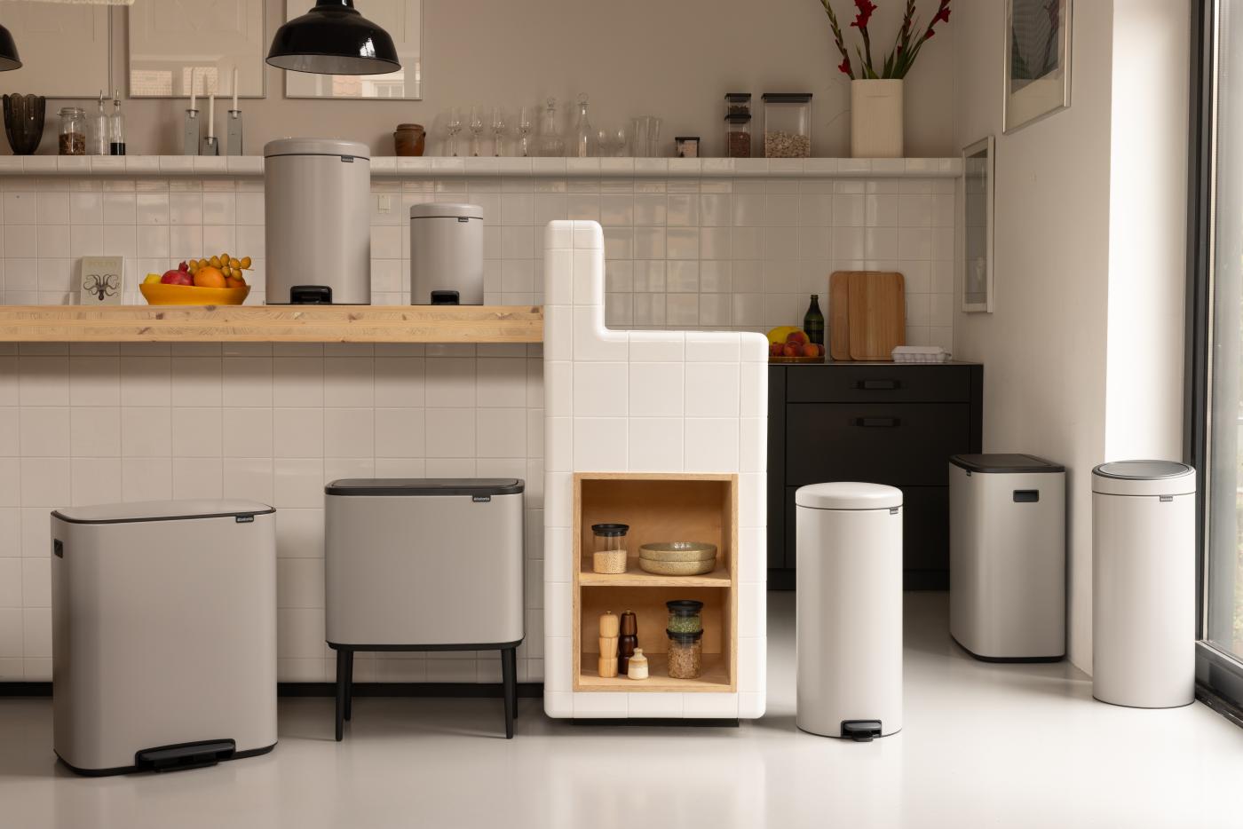 Alle soorten touch bins van groot tot klein in Soft Grey. Sommige hebben poten en andere niet. De kamer lijkt op een keuken met een warme, gezellige sfeer en een licht thema
