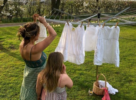 Frau und Kind hängen Wäsche an der Luft auf
